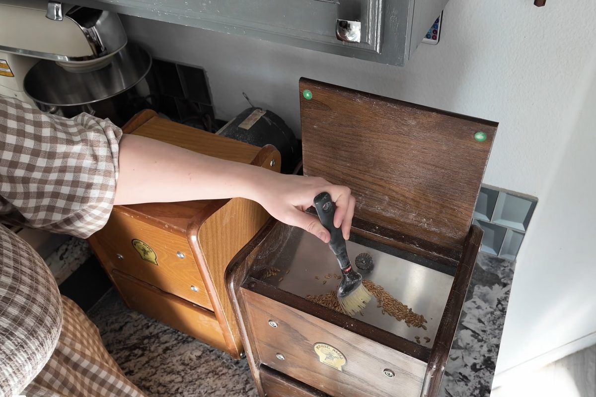 Module 5, Step by Step Milling Tutorial: brushing grain into a wooden grain mill